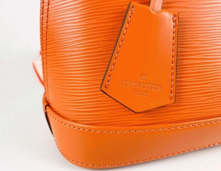 Reference image illustrating Replica Louis Vuitton Epi Leather Alma BB Handbag in Orange with Jacquard Strap