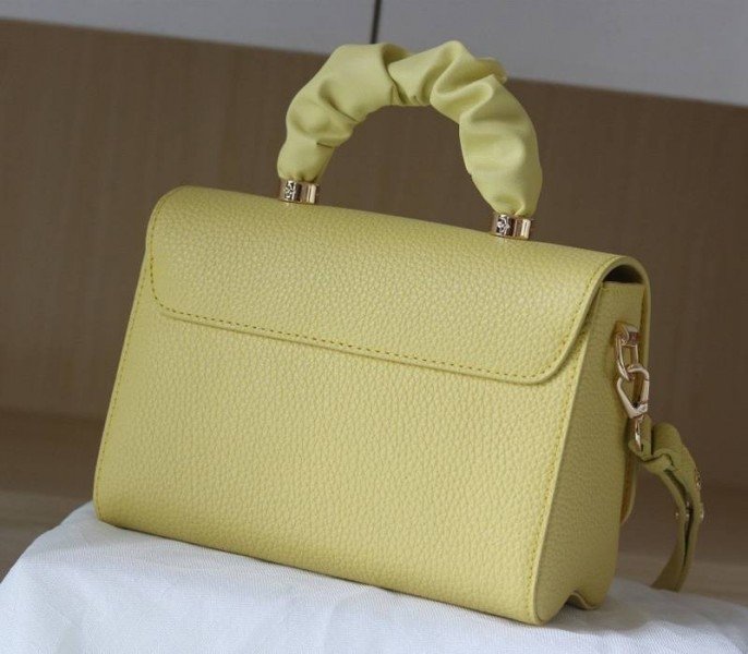 Reference image illustrating Replica Louis Vuitton Twist MM Scrunchie Handle in Ginger Yellow Taurillon Leather